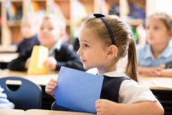 girl at desk holding purple folder